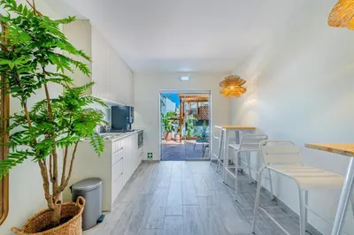 a kitchen with white cabinets and bar stools at The 23 Suites in Faro