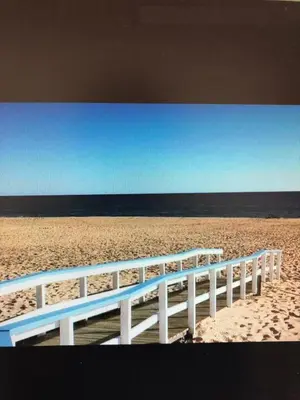 a white fence on a beach with the ocean at Beach Apartment Vilamoura Villa Columbus in Vilamoura