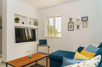 a living room with a blue couch and a table at Apartment Maresias 120 m Oura Beach By Bedzy in Albufeira