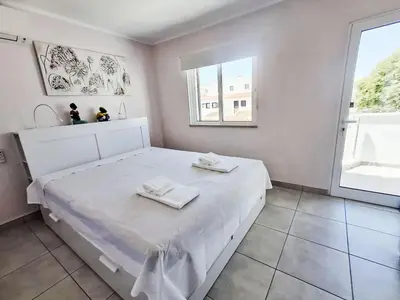 a white bed in a room with a window at Holiday Home Villa Medusa by Interhome in Vilamoura