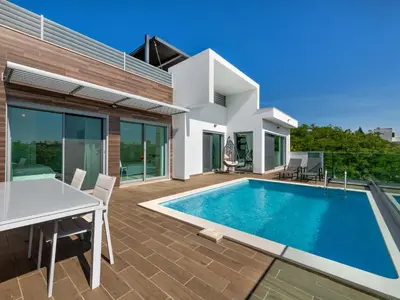 a villa with a swimming pool and a house at Villa Linda V3 Lote 67 - VIP Properties by Interhome in Albufeira
