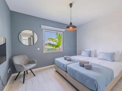 a kitchen and living room with a couch and a clock at Holiday Home Miguel VIP Properties by Interhome in Albufeira
