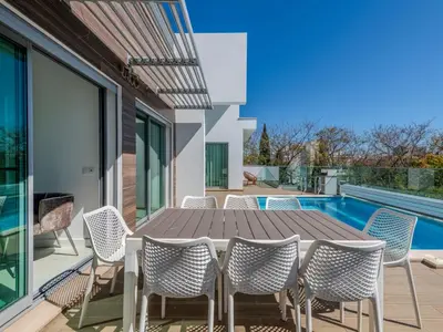 a patio with a table and chairs next to a swimming pool at Villa Vitória V3 Lote 68 - VIP Properties by Interhome in Albufeira