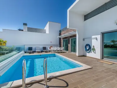 a swimming pool in the backyard of a house at Villa Vitória V3 Lote 68 - VIP Properties by Interhome in Albufeira