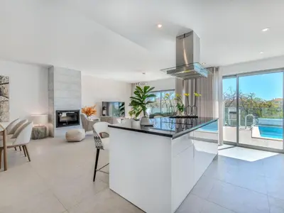 a kitchen with white appliances and a counter with chairs at Villa Vitória V3 Lote 68 - VIP Properties by Interhome in Albufeira