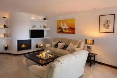 a living room with a white couch and a fireplace at Ocean Bliss II- Panoramic Sea View - 20m to Beach - 2 Swimming Pools - Private Parking in Albufeira