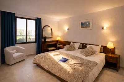 a bedroom with a bed and a chair and a window at Ocean Bliss II- Panoramic Sea View - 20m to Beach - 2 Swimming Pools - Private Parking in Albufeira