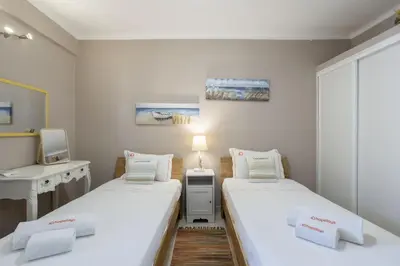 a small room with two beds and a desk at Forte Beach Retreat - 2BR Apartment with Terrace & AC in Caliços