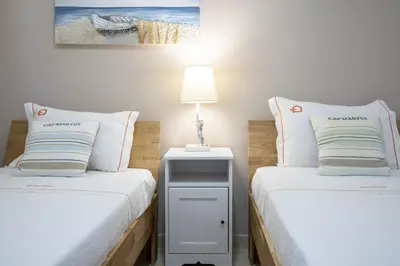 a bedroom with two beds and a lamp on a table at Forte Beach Retreat - 2BR Apartment with Terrace & AC in Caliços