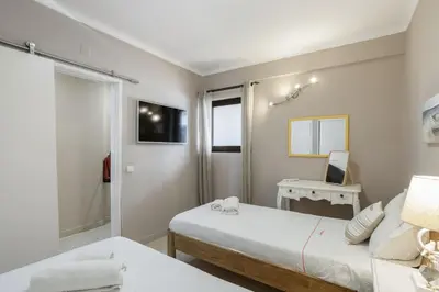 a small bedroom with a bed and a window at Forte Beach Retreat - 2BR Apartment with Terrace & AC in Caliços