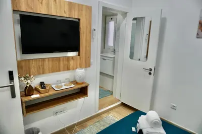 a living room with a tv and a bathroom at Casa Tapada do Bento II- Albufeira in Albufeira