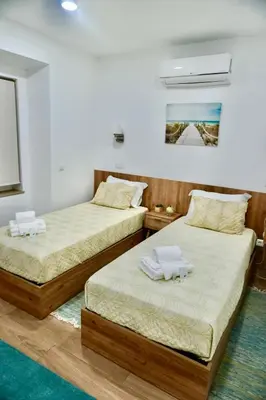 two beds sitting in a room with at Casa Tapada do Bento II- Albufeira in Albufeira