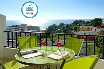 a balcony with a table and two glasses of wine at Atlantic Horizon by Seareen in Albufeira