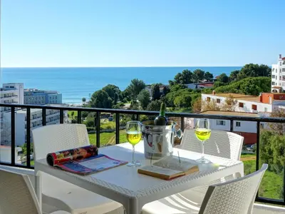 a table with two glasses of white wine on a balcony at Atlantic Horizon by Seareen in Albufeira
