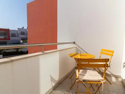 a yellow table and a chair on a balcony at Vitismar Apartment by Stay ici Algarve Holiday Rental in Guia