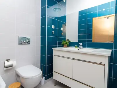 a bathroom with a toilet and a sink and blue tiles at Vitismar Apartment by Stay ici Algarve Holiday Rental in Guia