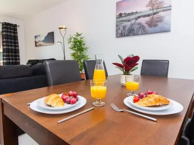 two plates of croissants and fruit on a wooden table at Vitismar Apartment by Stay ici Algarve Holiday Rental in Guia