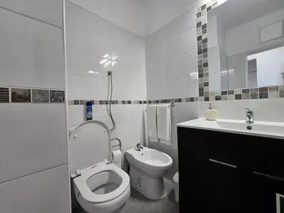 a white bathroom with a toilet and a sink at Sunset in Albufeira