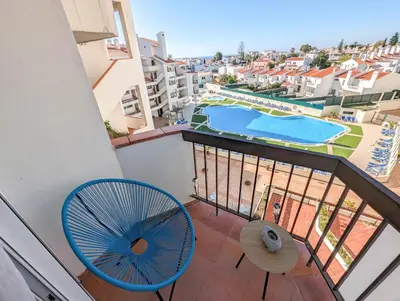 a balcony with a blue fan and a swimming pool at Sunset in Albufeira