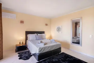 a bedroom with a large bed and a mirror at Apartamento Perfeito in Albufeira
