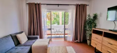 a living room with a couch and a large window at Appartement Touristique dans une résidence Hôtelière Silchoro in Albufeira