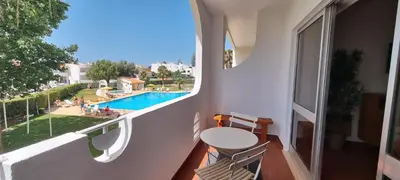 a balcony with a table and a view of a pool at Appartement Touristique dans une résidence Hôtelière Silchoro in Albufeira
