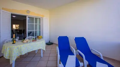 a dining room with a table and blue chairs at Greice Homes - T2 - JV - Vilamoura Centre in Quarteira