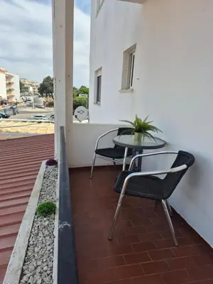 a patio with a table and chairs on a balcony at Costa Mar by Albufeira Rental in Olhos de Água