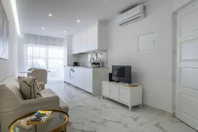 a living room with a couch and a tv at Baleeira Sea View Studio in Albufeira