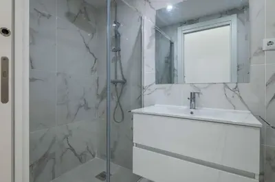 a bathroom with a shower and a sink and a mirror at Baleeira Sea View Studio in Albufeira
