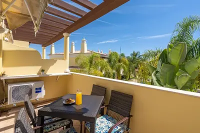 a patio with a table and chairs on a balcony at Casa Vista Brejos in Albufeira
