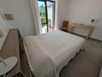 a white bed in a room with a window at Solar dos Pinheiros T3 in Vilamoura
