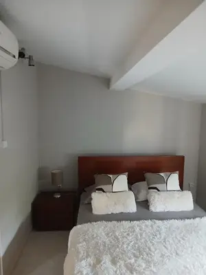 a bedroom with a bed with white sheets and pillows at Maison entière 10-12 personnes à Goldra de çima Loulé in Loulé