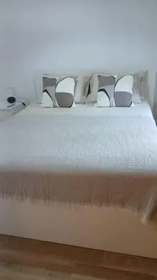 a white bed with pillows on top of it at Maison entière 10-12 personnes à Goldra de çima Loulé in Loulé