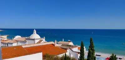 a white building with a red roof and the ocean at Sea Paradise in Albufeira
