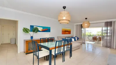 a dining room and living room with a table and chairs at Mediterraneo 2ºB - CD 318, Cleverdetails - sleeps 2 adults and 1 child in Vilamoura