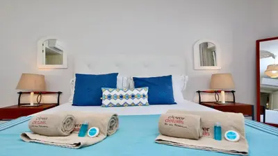 a bed with blue pillows and towels on it at Mediterraneo 2ºB - CD 318, Cleverdetails - sleeps 2 adults and 1 child in Vilamoura