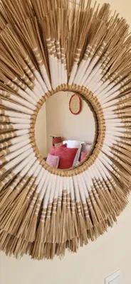 a circular mirror hanging on a wall with a bed at Casa Amani in Loulé