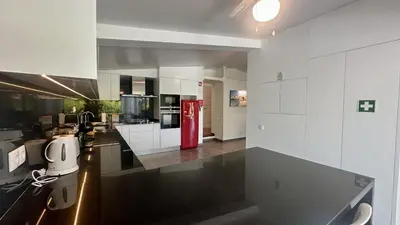 a kitchen with white cabinets and a red refrigerator at Tropicana by Check-in Portugal in Albufeira