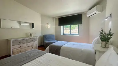 a bedroom with two beds and a chair and a window at Tropicana by Check-in Portugal in Albufeira