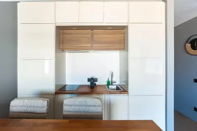 a kitchen with white cabinets and a sink at Gorgeous Flat 3min Walk to Beach in Albufeira