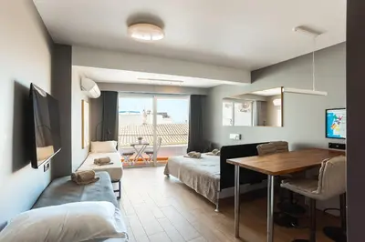 a living room with a bed and a dining room table at Gorgeous Flat 3min Walk to Beach in Albufeira