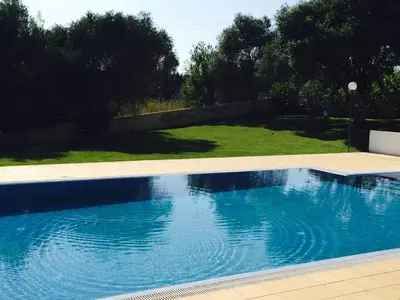 a swimming pool with blue water in a yard at Albufeira Luxury Villa in Albufeira