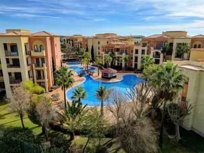 an aerial view of a resort swimming pool with palm trees at VILAMOURA - The Residences in Quarteira