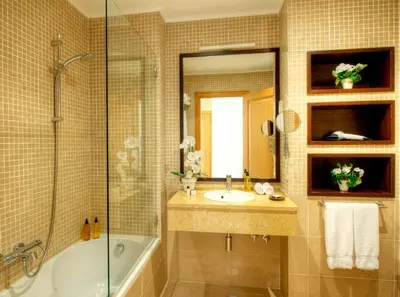 a bathroom with a sink and a tub and a mirror at VILAMOURA - The Residences in Quarteira