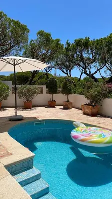 a swimming pool with a frisbee and an umbrella at Vila Antic in Almancil