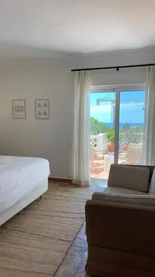 a bedroom with a bed and a view of the ocean at Vila Antic in Almancil