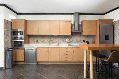 a kitchen with wooden cabinets and stainless steel appliances at Casa Do Vale - Algarve in Vargem da Mão