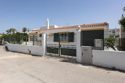 a white fence in front of a house at Vila Coelho - City center with pool by HD in Vale de Pedras