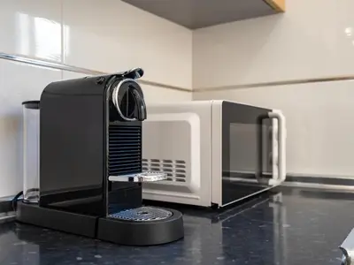 a microwave oven sitting on top of a kitchen counter at Duplex T2 com terraço e BBQ em Vilamoura in Quarteira